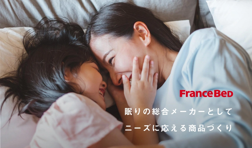 母と子がベッドで寝ながら顔を向き合わせている画像