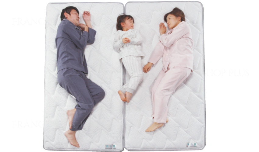 家族3人でマットレスに寝ている画像
